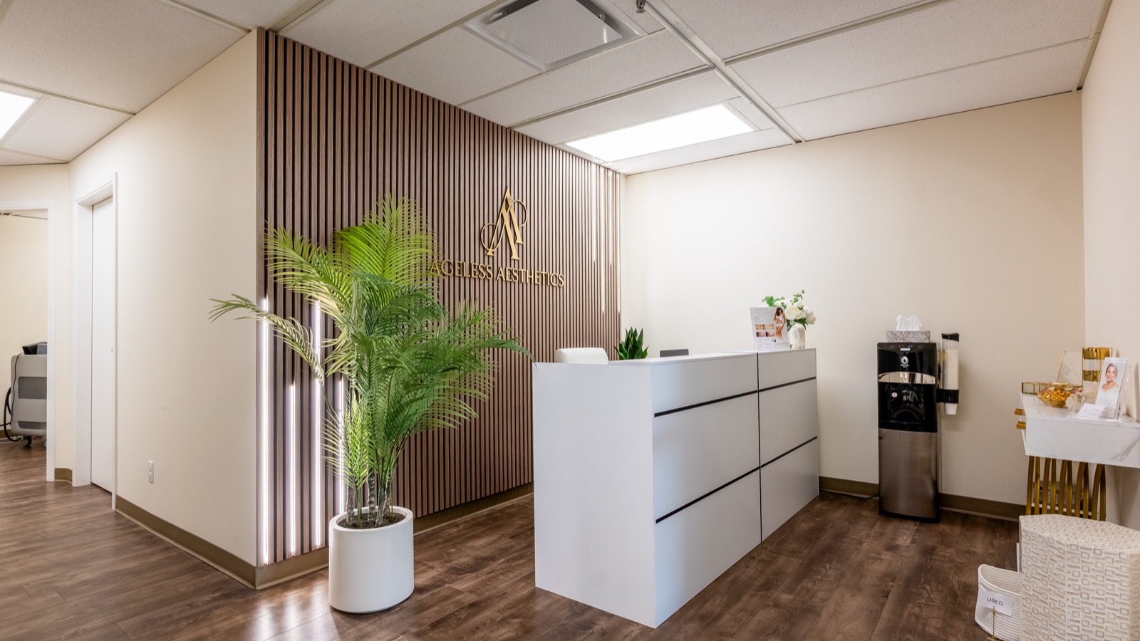 Reception area of Ageless Esthetics Calgary with brand logo wall