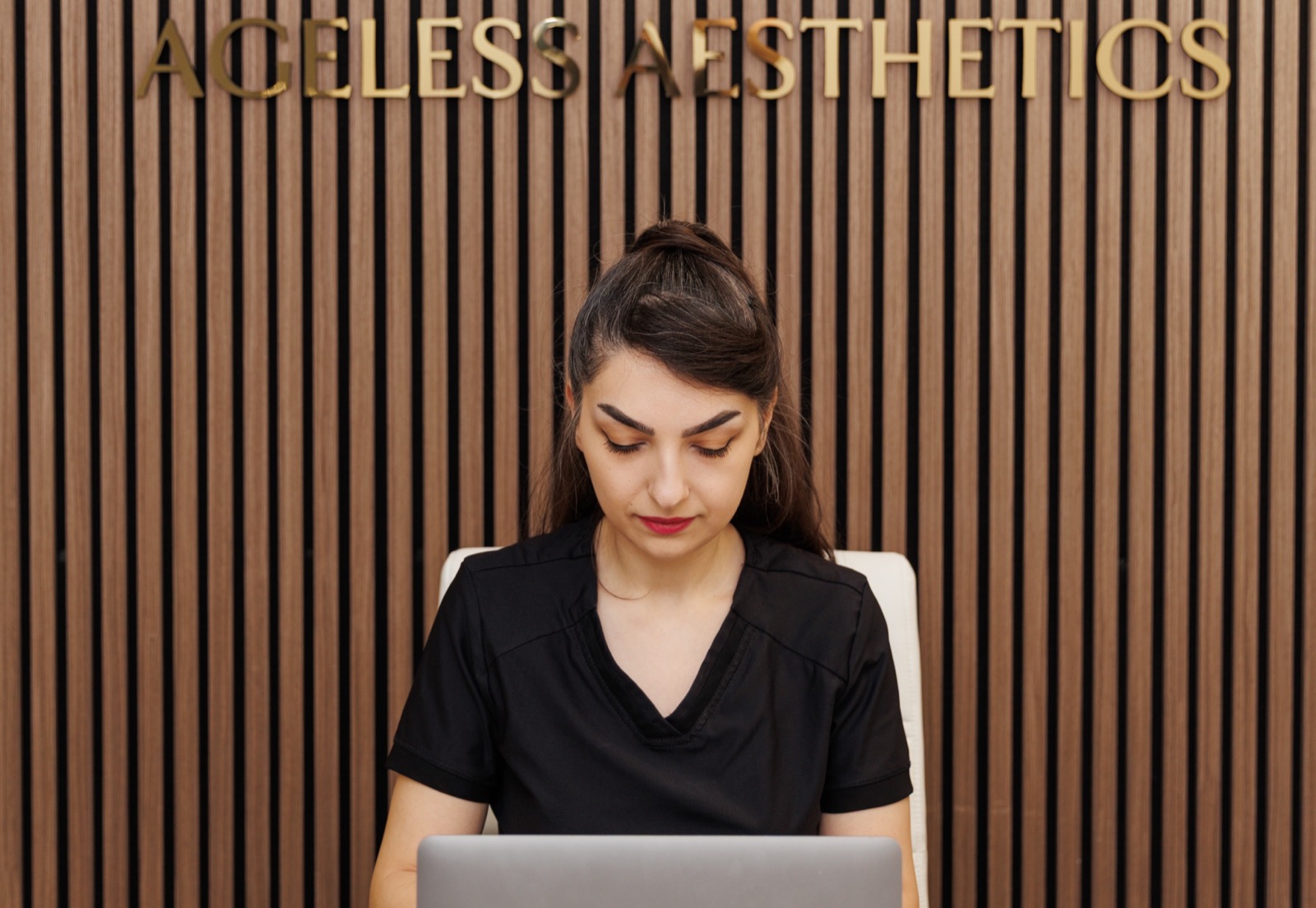 Leila at the reception desk of Ageless Esthetics Calgary